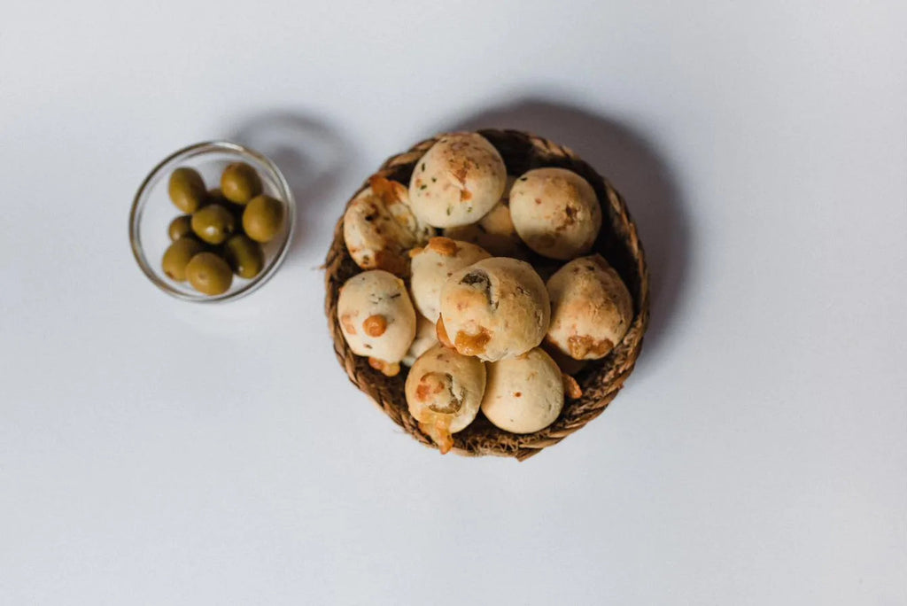 Canasta de chipás de olivas junto a un cuenco con aceitunas verdes
